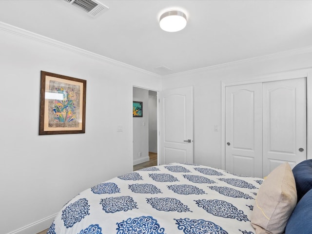 bedroom with crown molding, a closet, and baseboards