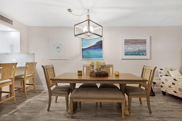 dining area with a notable chandelier and hardwood / wood-style flooring