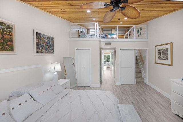 unfurnished bedroom featuring a high ceiling, light wood-type flooring, and wood ceiling