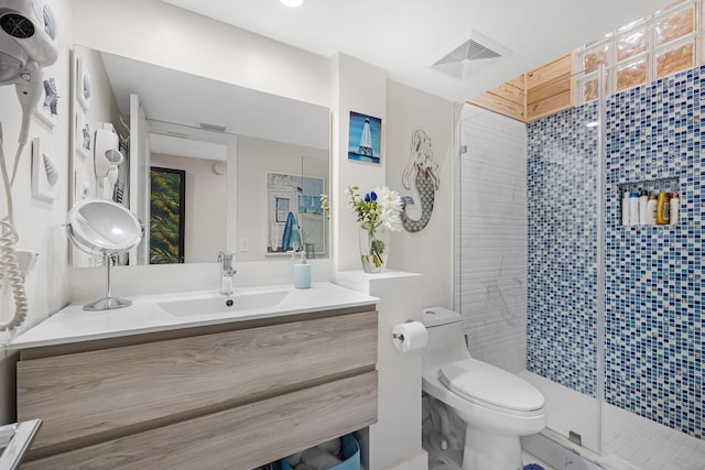 bathroom featuring vanity, toilet, and a shower with door