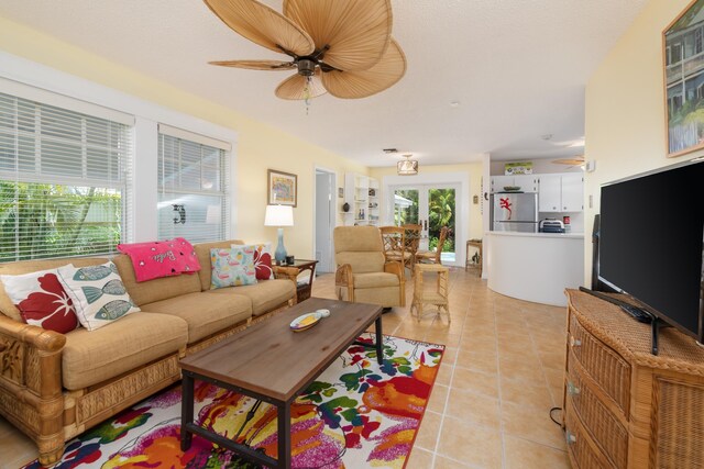 tiled living room featuring ceiling fan and french doors