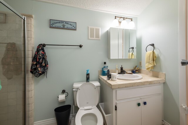 bathroom featuring vanity, toilet, a textured ceiling, and walk in shower