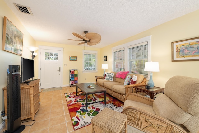 living room featuring light tile patterned floors, a textured ceiling, and ceiling fan