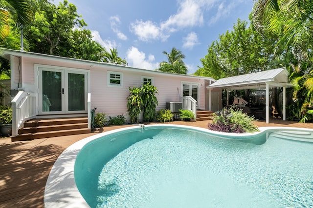 view of pool with cooling unit, a gazebo, and french doors