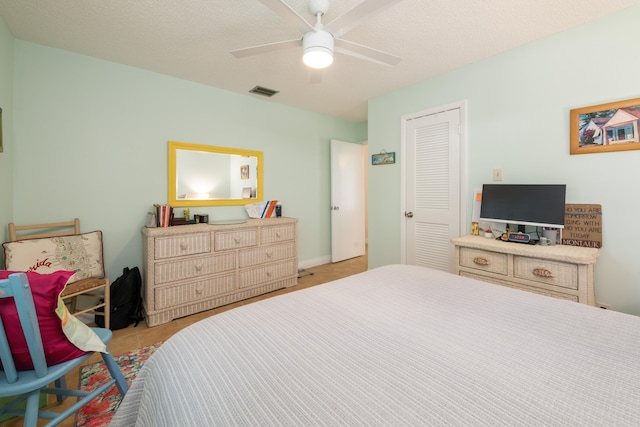 bedroom with ceiling fan, a textured ceiling, and a closet