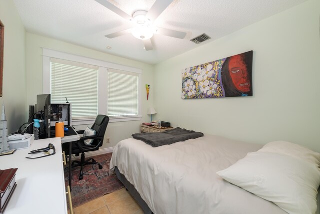 bedroom with light tile patterned flooring, ceiling fan, and a textured ceiling