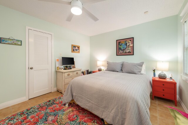 tiled bedroom featuring ceiling fan