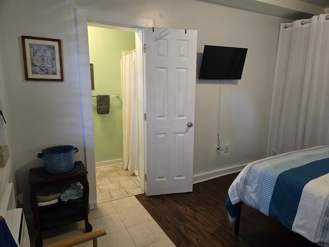 bedroom with baseboards and wood finished floors