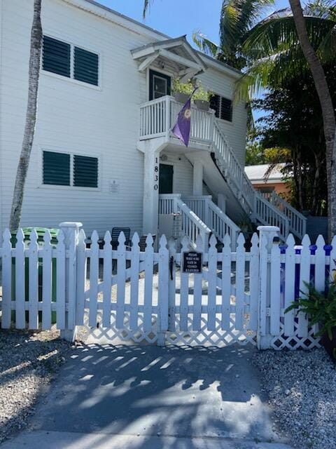 view of front facade with a fenced front yard, a balcony, and a gate