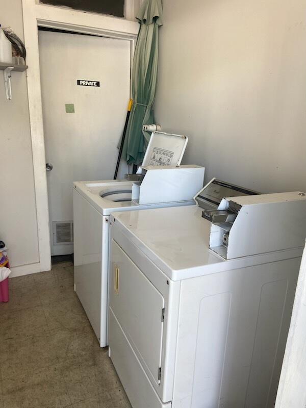 laundry room featuring laundry area, light floors, visible vents, and washing machine and clothes dryer