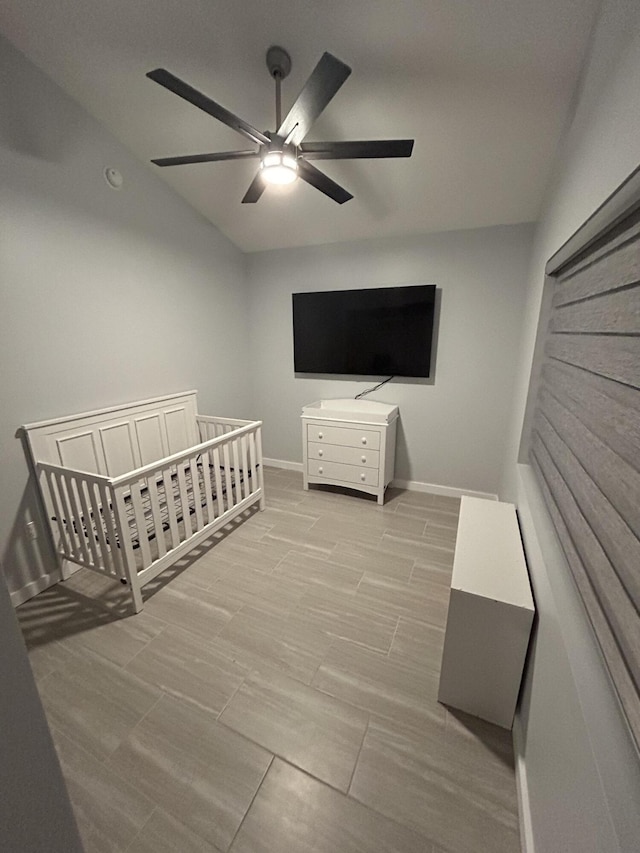 bedroom with ceiling fan and a crib