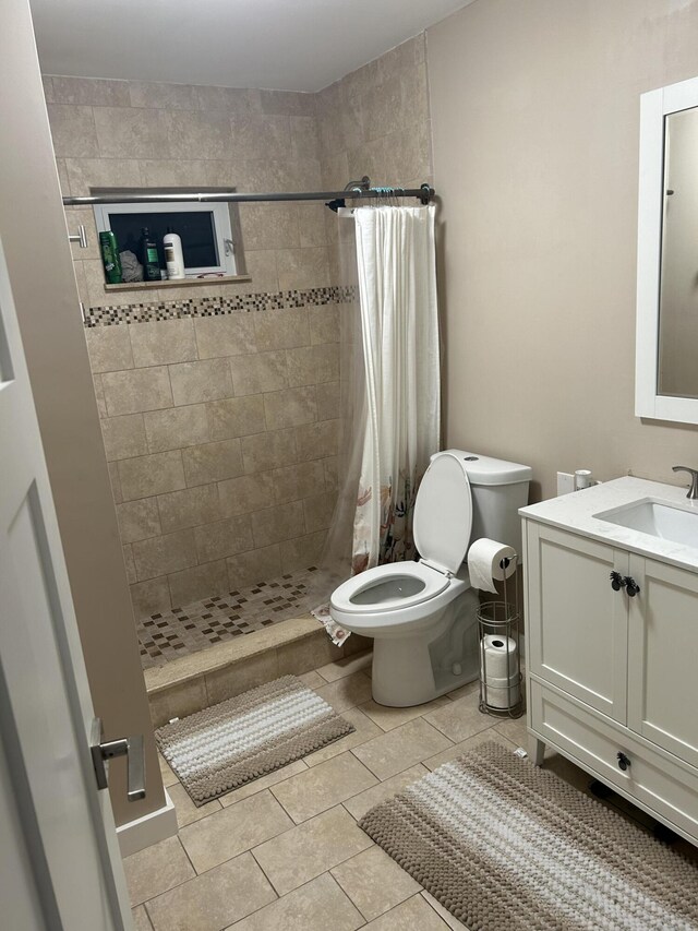 bathroom with walk in shower, tile patterned floors, vanity, and toilet