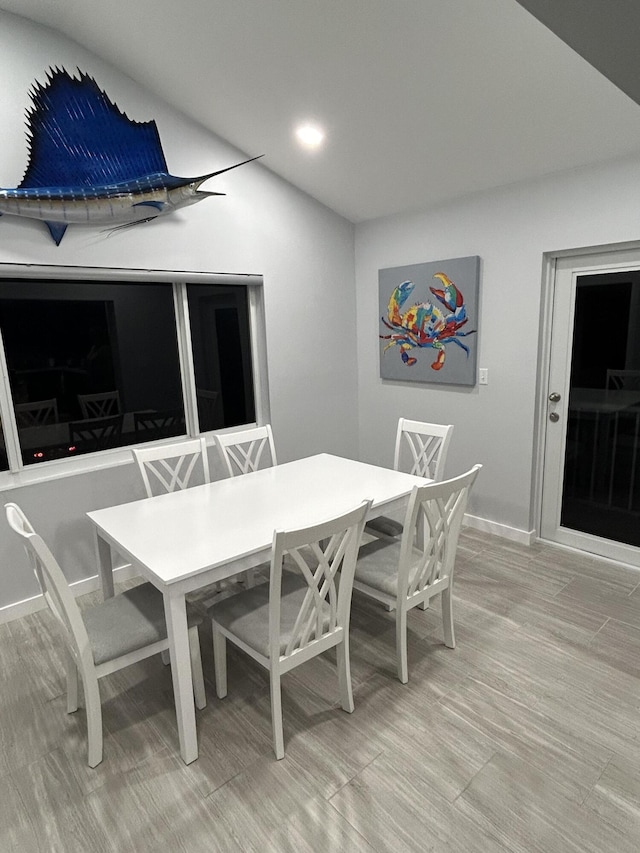 dining area with lofted ceiling and hardwood / wood-style floors