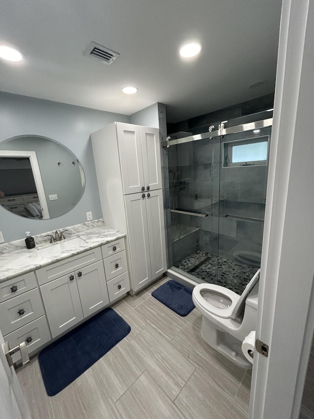 bathroom featuring vanity, toilet, and walk in shower