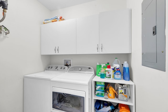 clothes washing area featuring cabinet space, washing machine and dryer, and electric panel