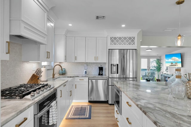 kitchen featuring white cabinets, a sink, light wood-style flooring, appliances with stainless steel finishes, and custom exhaust hood