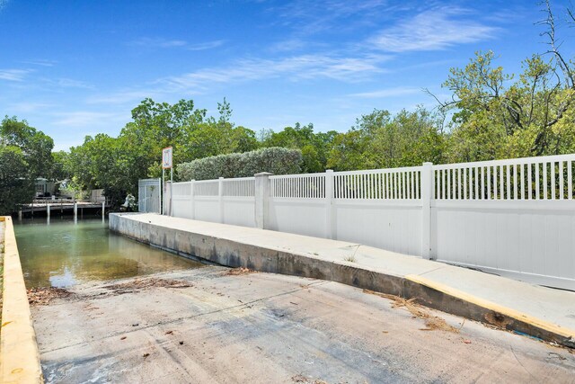 exterior space with fence and a water view