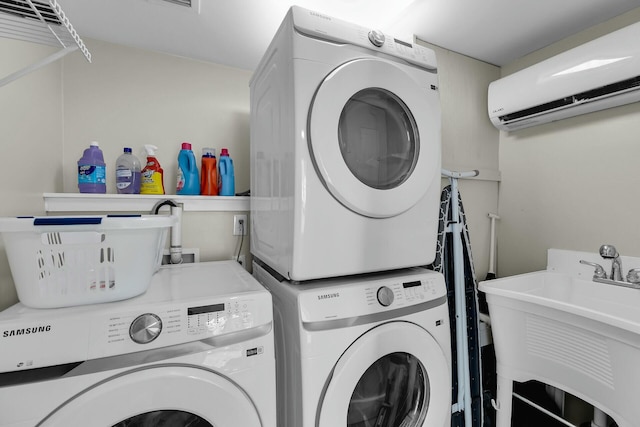 laundry area with stacked washer and clothes dryer, an AC wall unit, a sink, and laundry area