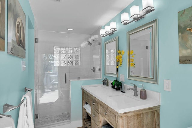 full bath with recessed lighting, a sink, double vanity, and a stall shower