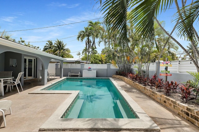 view of pool featuring a patio area, french doors, a fenced in pool, and a fenced backyard