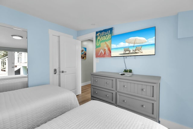 bedroom with baseboards and wood finished floors