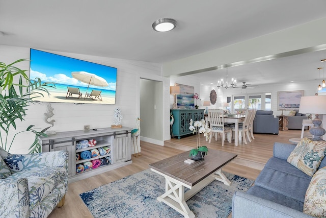 living room featuring light wood finished floors and an inviting chandelier