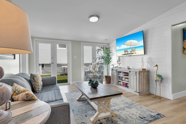 living area featuring light wood finished floors, french doors, and baseboards