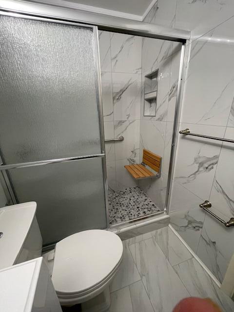1608 Venetian Dr, Key West, FL 33040 - bathroom featuring marble look tiles, a stall shower, and vanity