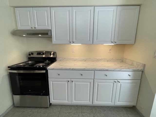 1608 Venetian Dr, Key West, FL 33040 - kitchen featuring stainless steel range with electric stovetop, under cabinet range hood, white cabinetry, and light tile patterned floors