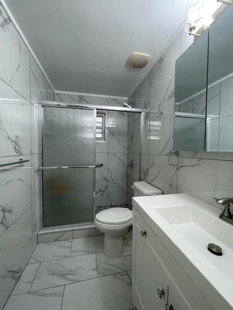 1608 Venetian Dr, Key West, FL 33040 - full bathroom featuring vanity, marble finish flooring, tile walls, and a marble finish shower