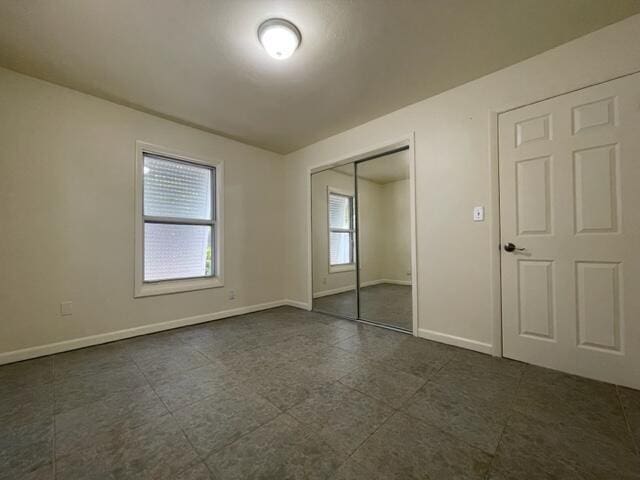1608 Venetian Dr, Key West, FL 33040 - unfurnished bedroom with a closet and dark tile patterned flooring