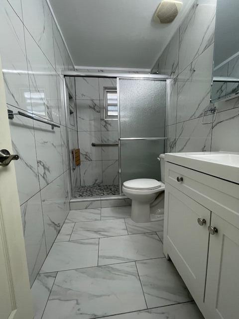 1608 Venetian Dr, Key West, FL 33040 - bathroom featuring marble look tiles, vanity, and a marble finish shower
