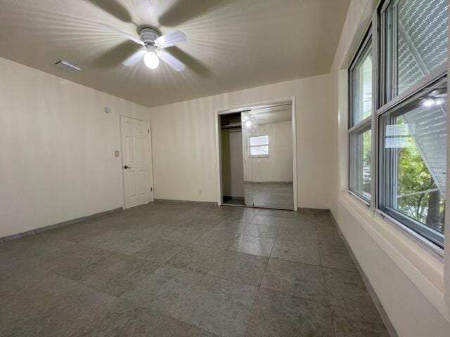 1608 Venetian Dr, Key West, FL 33040 - unfurnished bedroom with dark tile patterned flooring, a closet, and a ceiling fan
