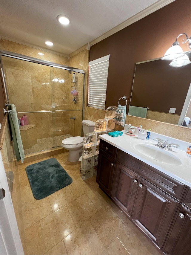 bathroom featuring crown molding, vanity, toilet, and a shower with shower door