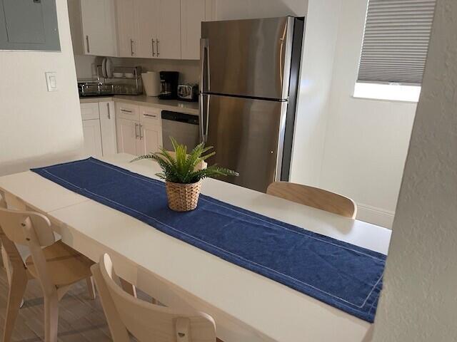 kitchen featuring white cabinets, electric panel, appliances with stainless steel finishes, and light countertops