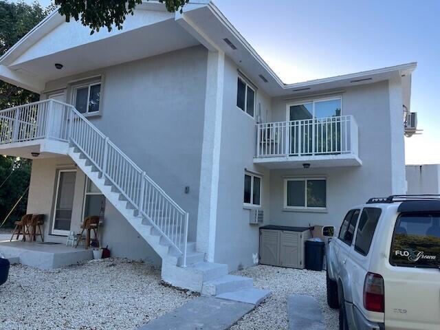 view of side of property featuring stairway and stucco siding