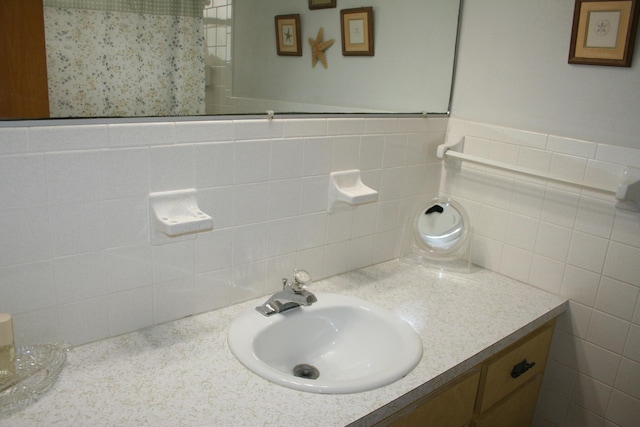 bathroom with vanity and tile walls