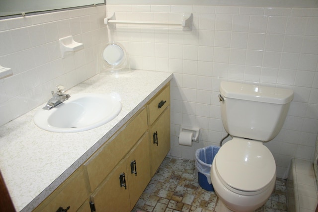 bathroom with vanity, tile walls, and toilet