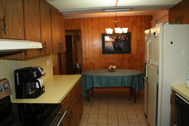 kitchen with stainless steel electric stove, wooden walls, hanging light fixtures, white fridge, and an inviting chandelier