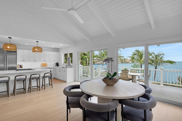 interior space with sink, a water view, high vaulted ceiling, light wood-type flooring, and beam ceiling