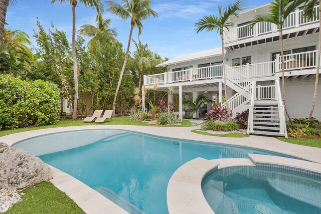 outdoor pool with stairway and a wooden deck