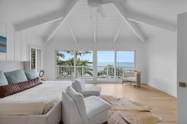 bedroom featuring vaulted ceiling with beams, a water view, wood finished floors, baseboards, and access to exterior