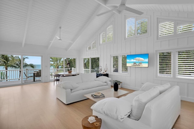 living area featuring beam ceiling, high vaulted ceiling, a ceiling fan, and wood finished floors