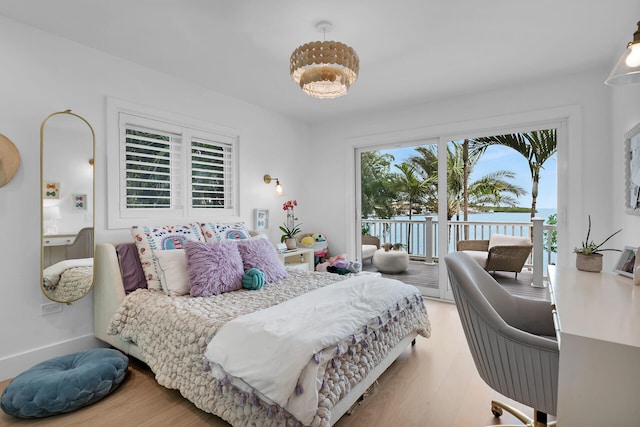 bedroom featuring access to outside, baseboards, and wood finished floors