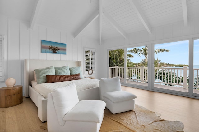 bedroom featuring vaulted ceiling with beams, access to exterior, a water view, and wood finished floors