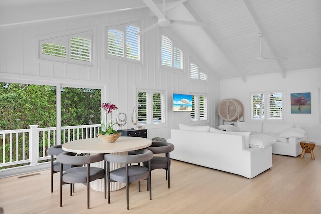 living room featuring light hardwood / wood-style flooring, high vaulted ceiling, and beamed ceiling