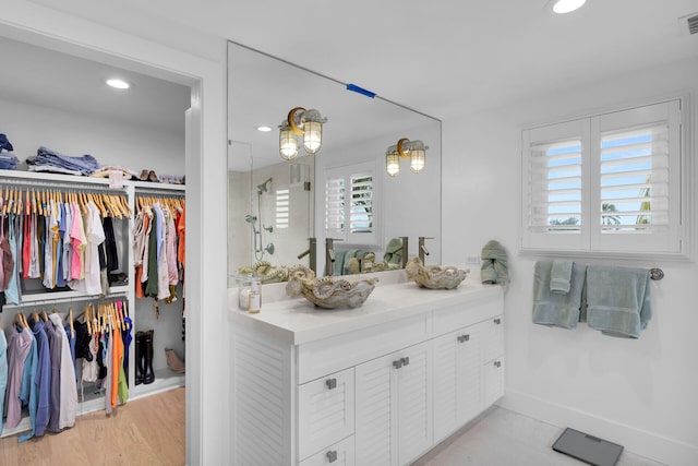 bathroom featuring visible vents, a walk in closet, vanity, a shower stall, and recessed lighting