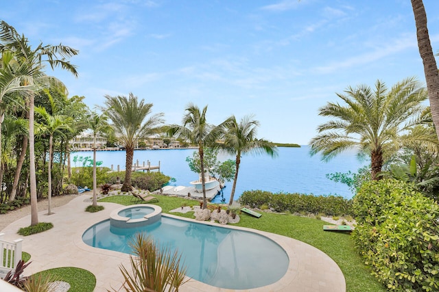 view of pool featuring a patio area, a pool with connected hot tub, a water view, and a lawn