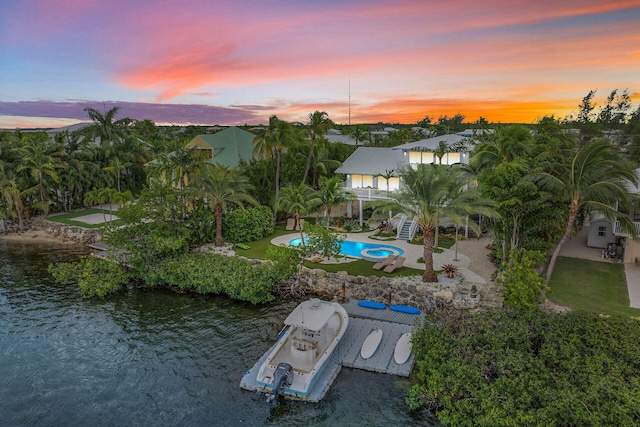 aerial view at dusk featuring a water view