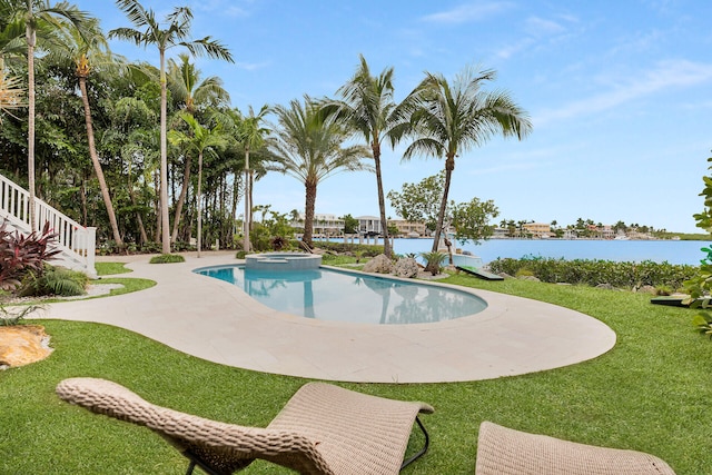 view of pool with a yard, a patio, a water view, and a pool with connected hot tub